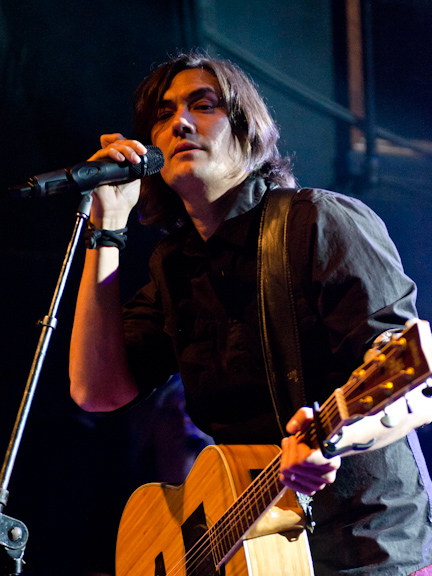David Usher singing and playing guitar during a Toronto concert.