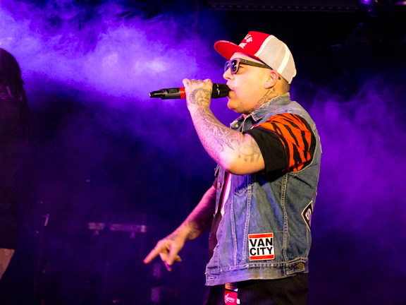 Swollen Members performing live under purple stage lights.
